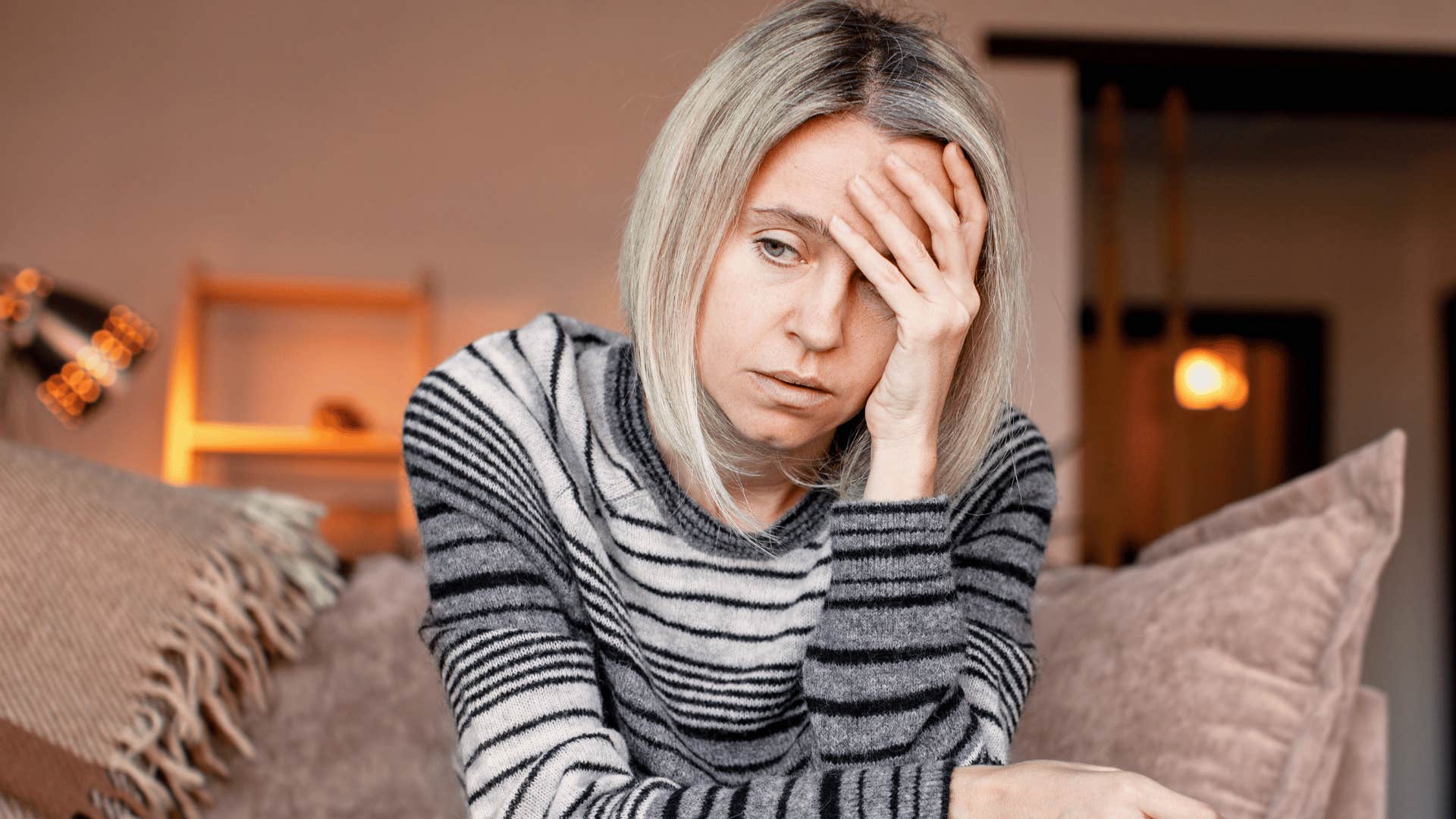 woman looking upset while sitting on the couch