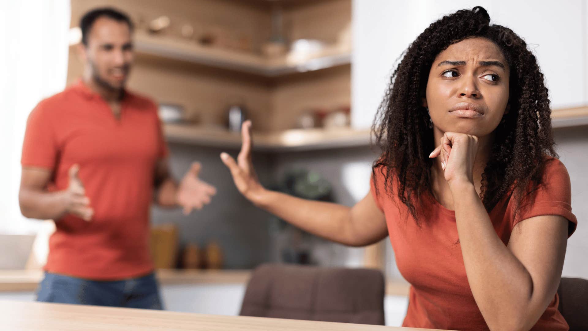 woman holding up hand to man annoyed 