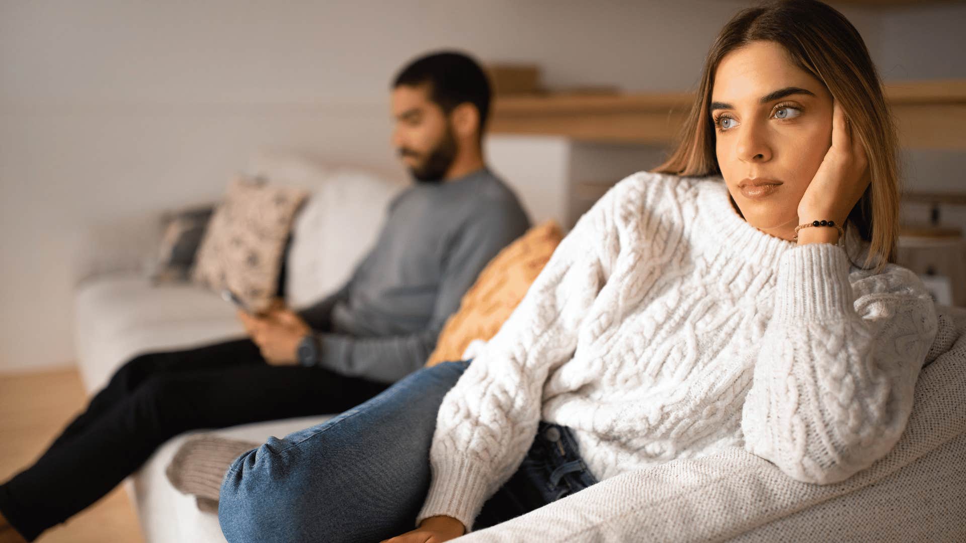 woman looking annoyed while man is on phone