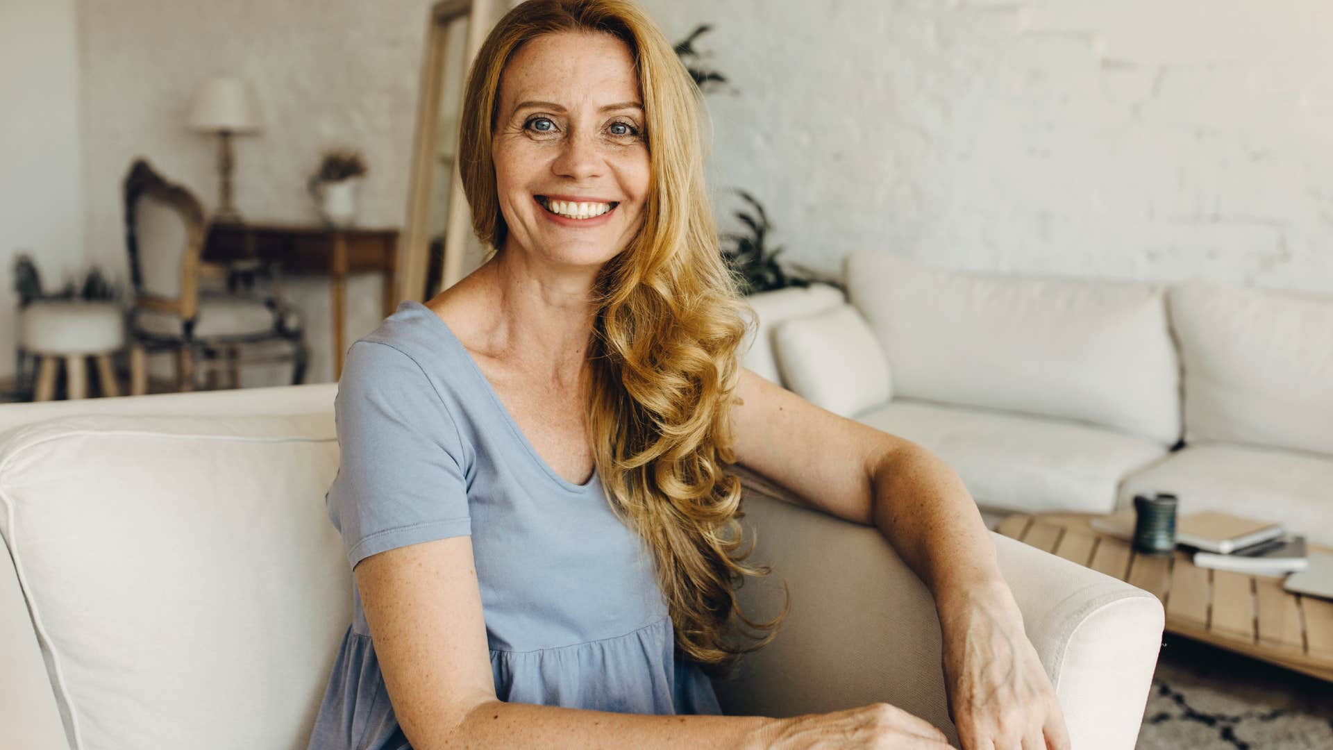 Woman smiling on her couch.