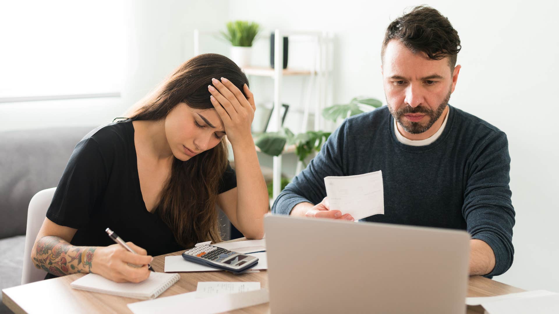 Couple looking stressed doing bills.