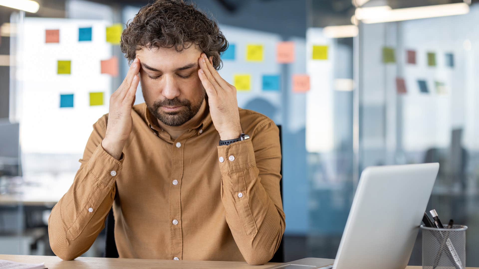 Man looking stressed at work in an office.