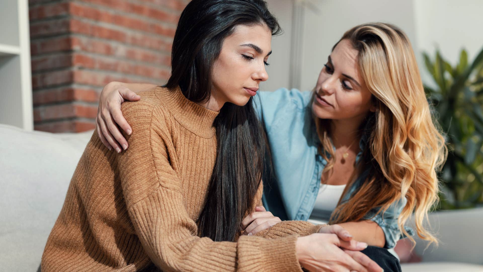 Sad woman being comforted by her friend. 