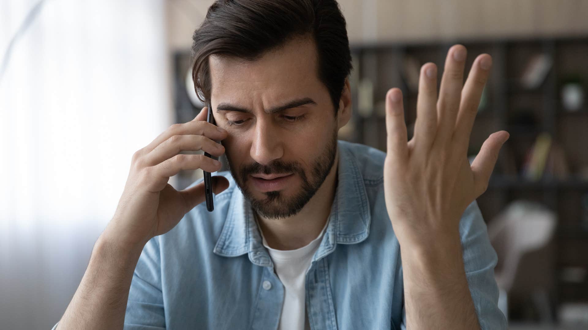 Man looking shocked talking on the phone.