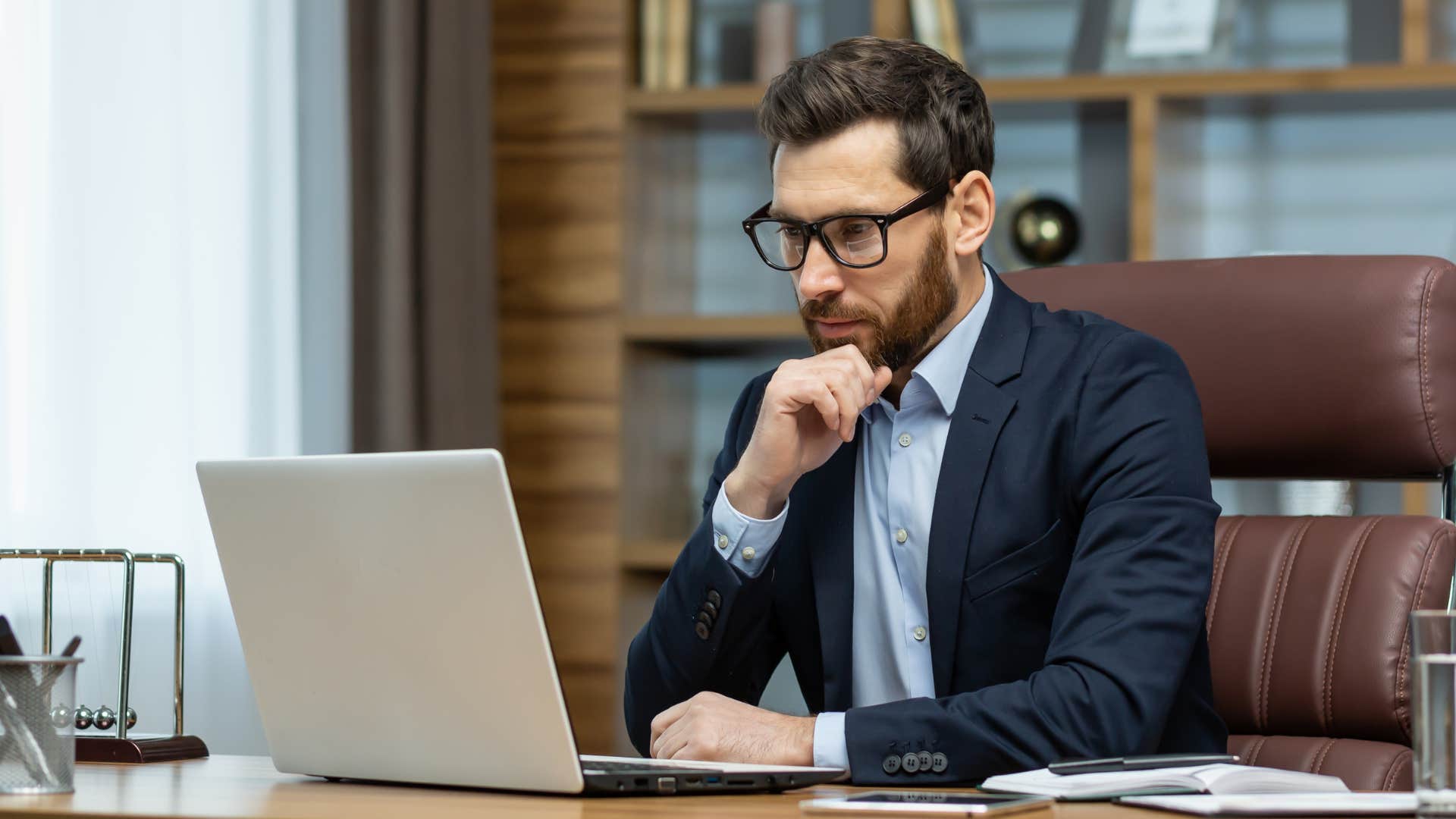 Professional man looking concerned staring at his laptop.