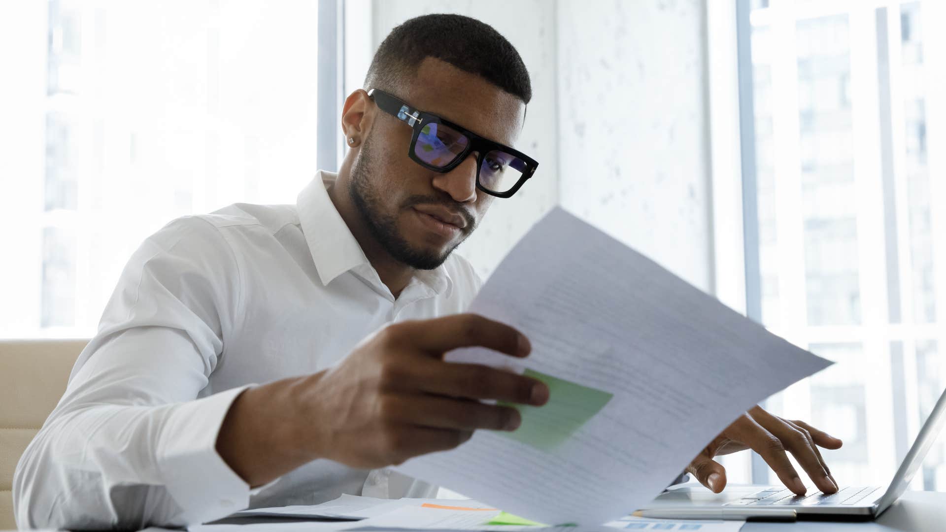 Man staring at a paper at his work desk.