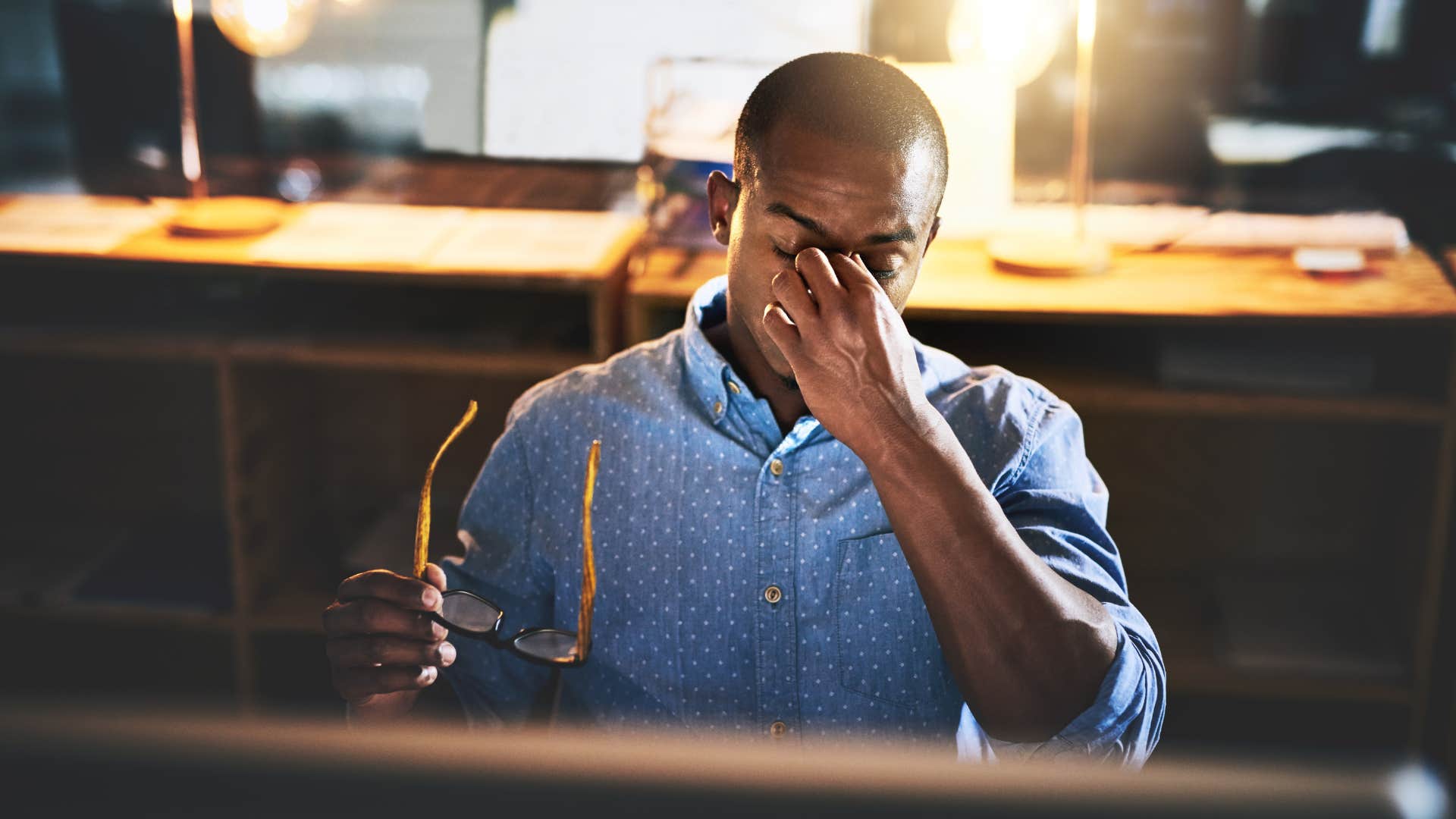 Man looking tired at his work desk. 