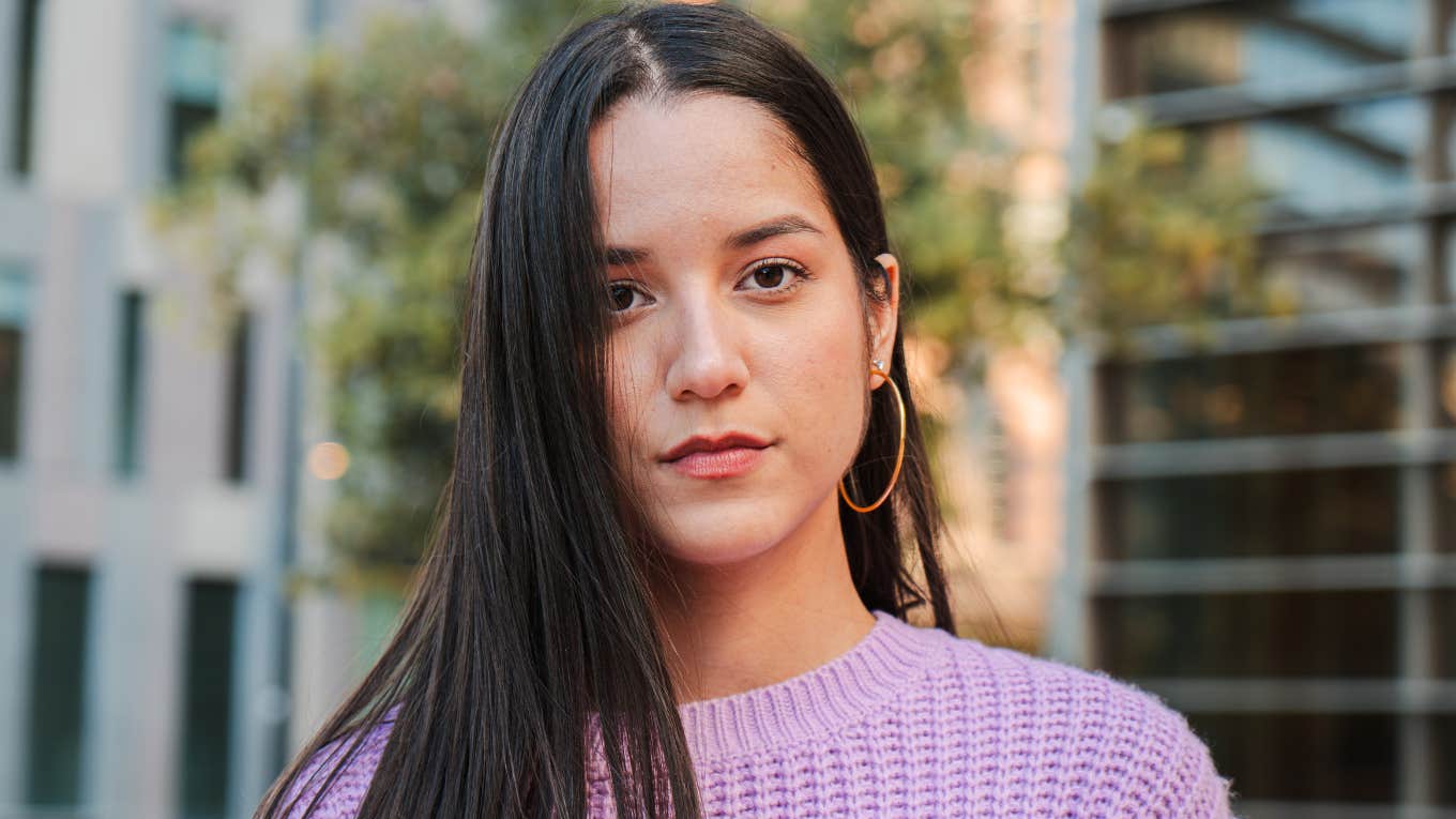 serious looking woman in purple sweater