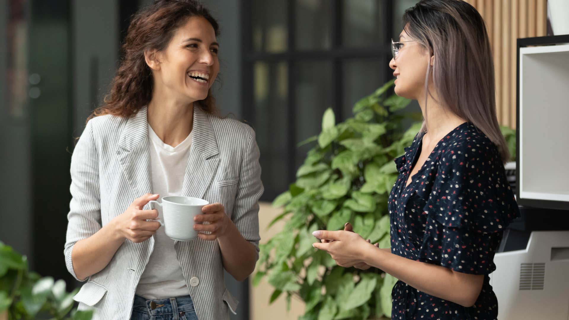 Two women smiling and talking to each other.