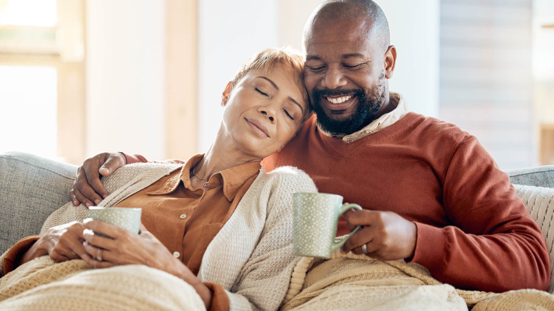 Older couple hugging and relaxing on the couch.