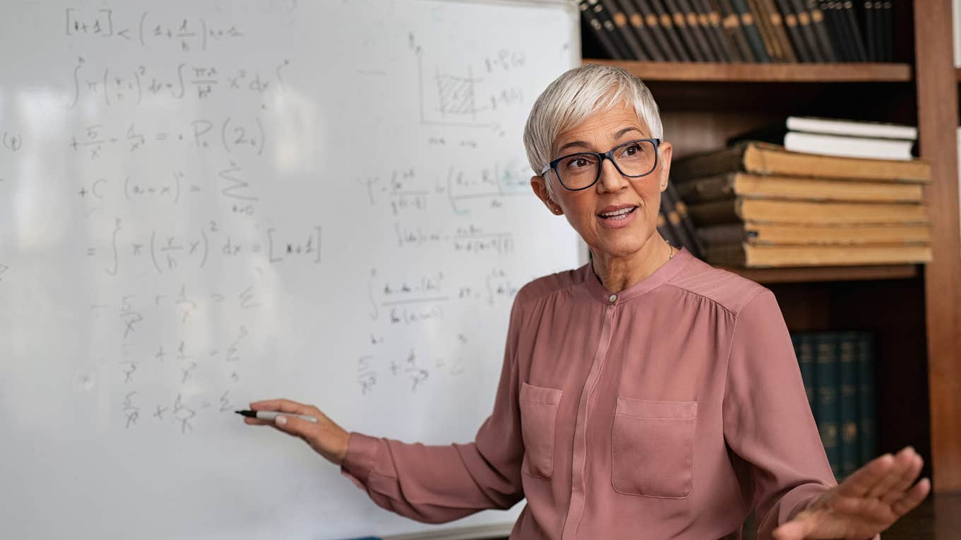 Stanford PhD sharing math equation on a whiteboard