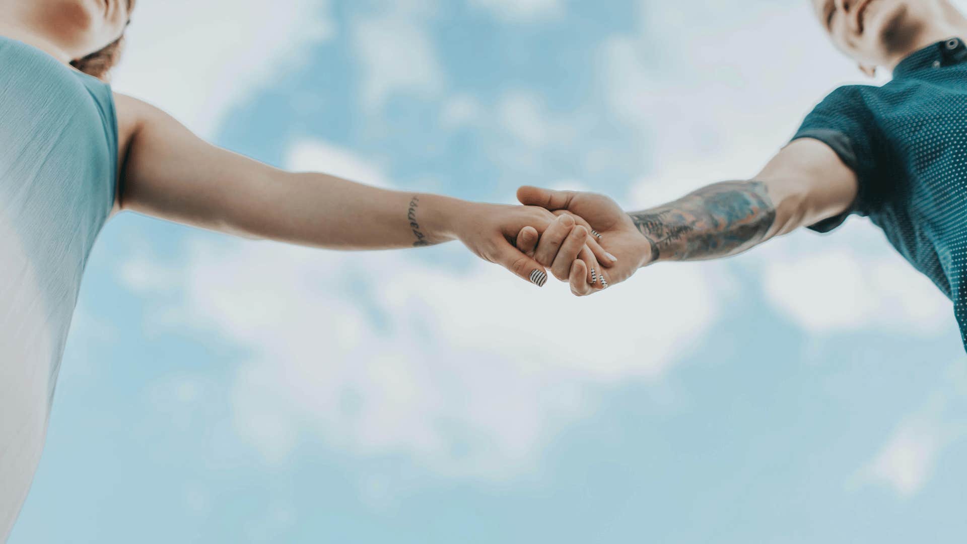 couple holding hands with the sky in the background