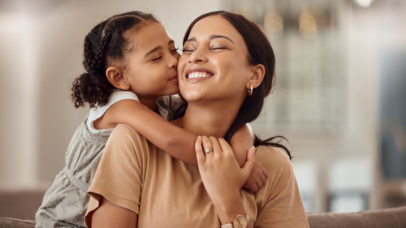 young girl giving mom kiss on the cheek