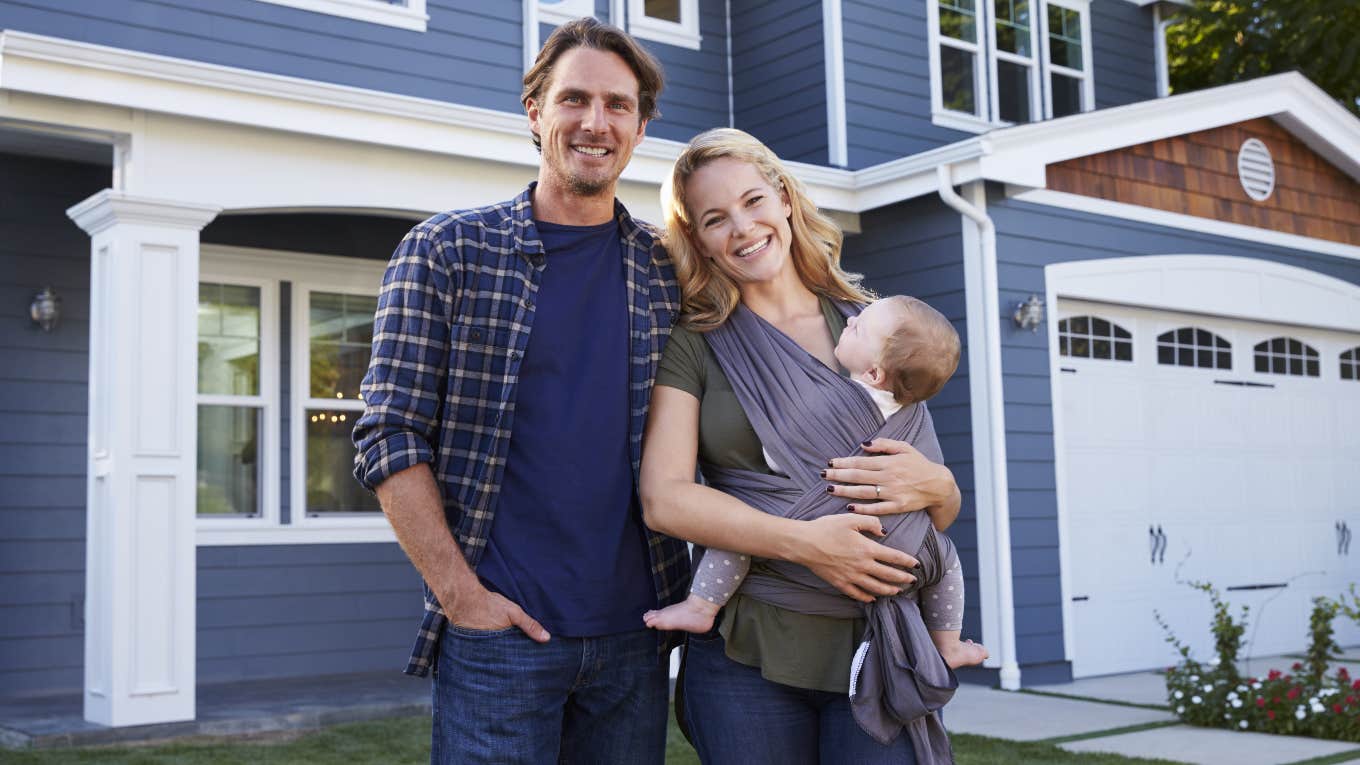 Young family standing in front of their HOA house