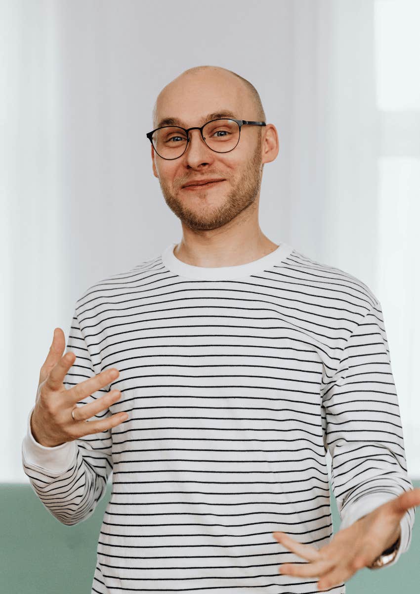 smiling man in glasses gesturing with his hands