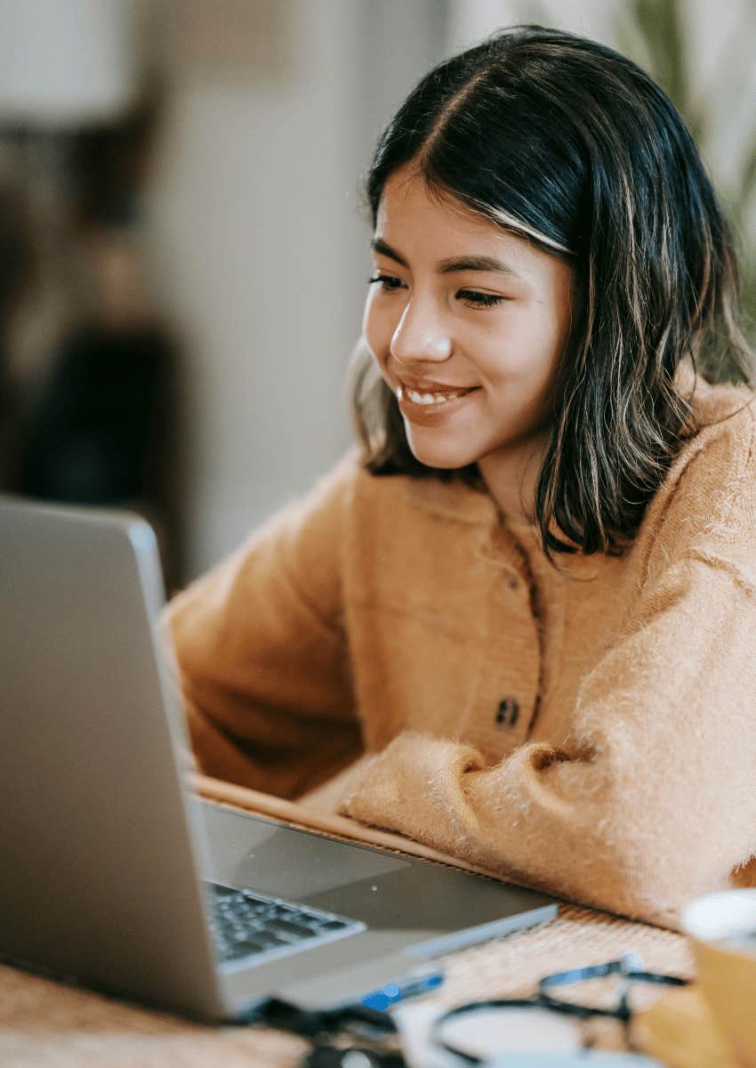 smiling young woman working on laptop