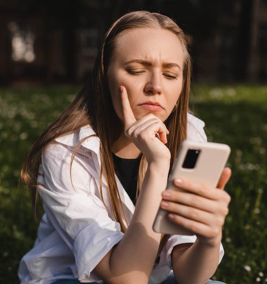 She looks at her mobile device and thin ks deeply