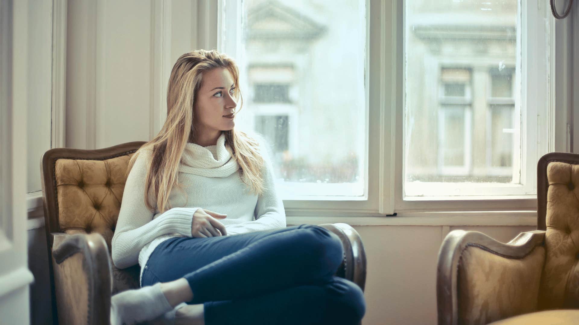 woman sitting down and looking out window