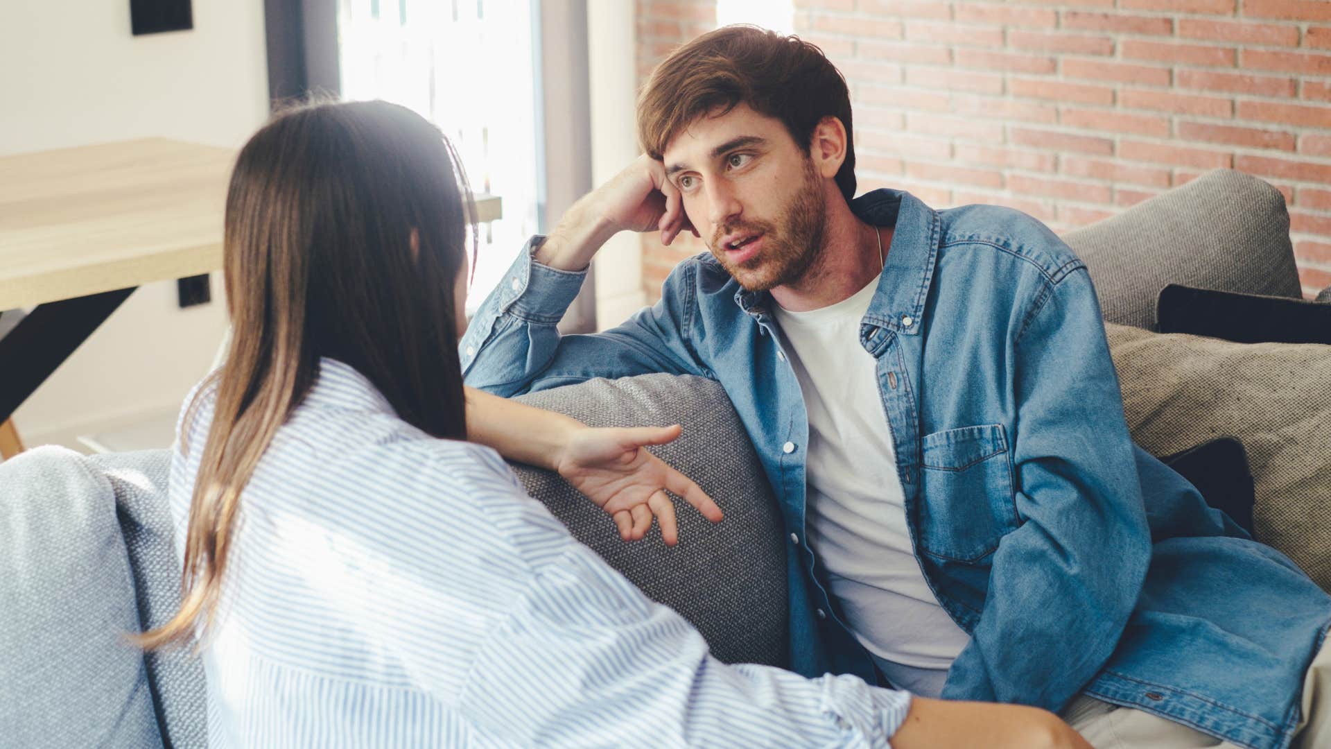 Man looking annoyed talking to his girlfriend.