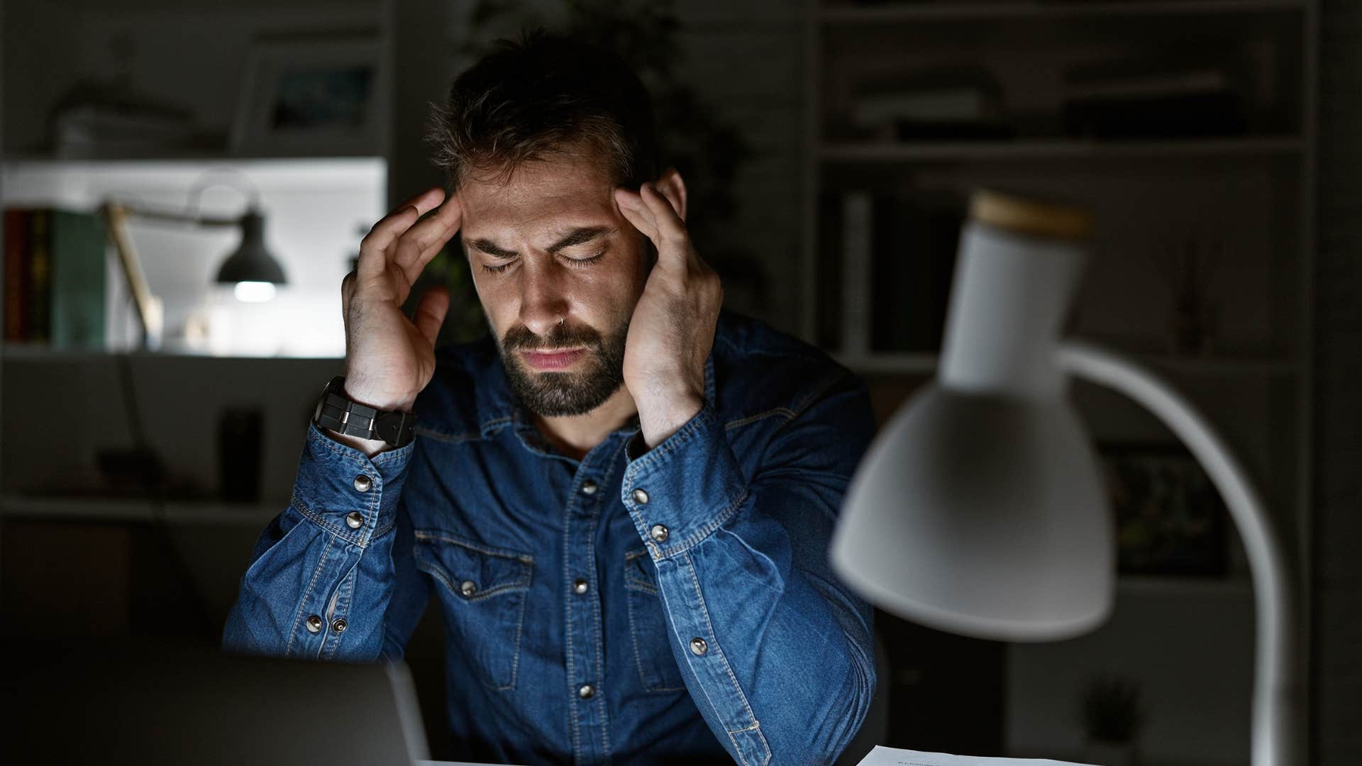 Man looking stressed at in his office at night.