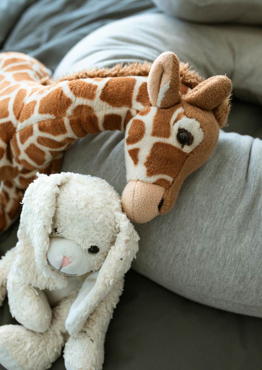 stuffed giraffe and rabbit with pillows