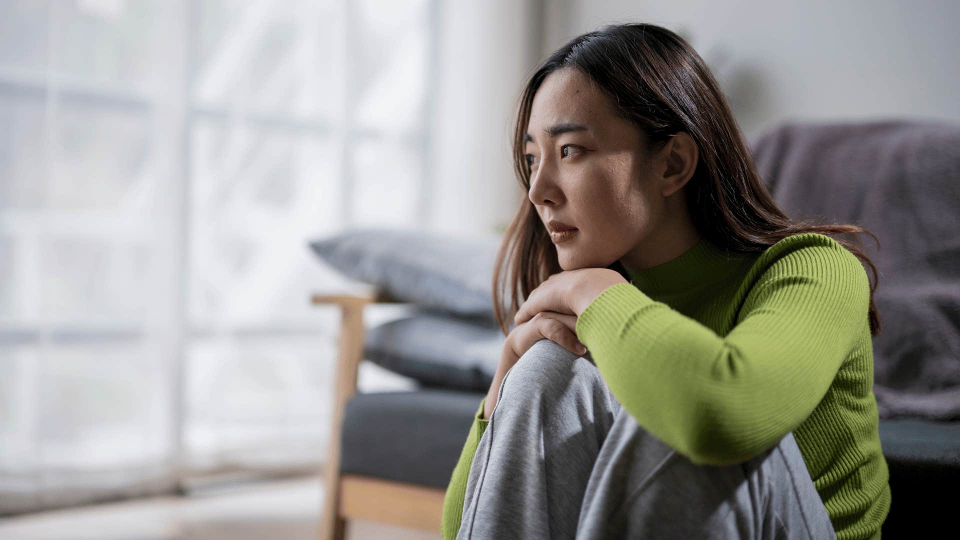 woman looking upset while sitting on the floor