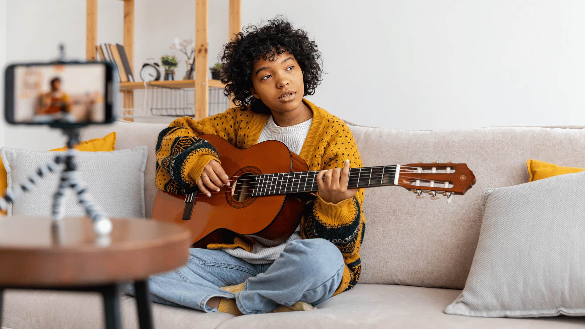 woman playing the guitar while recording 