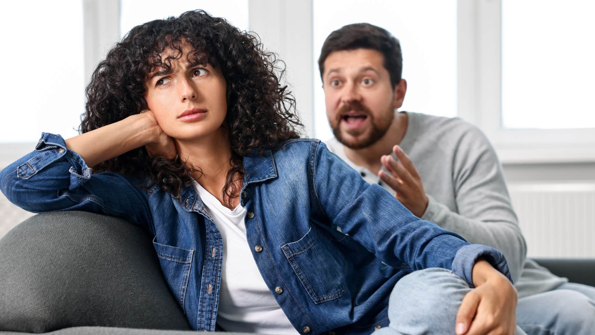 Woman looking away from a man who is yelling at her.