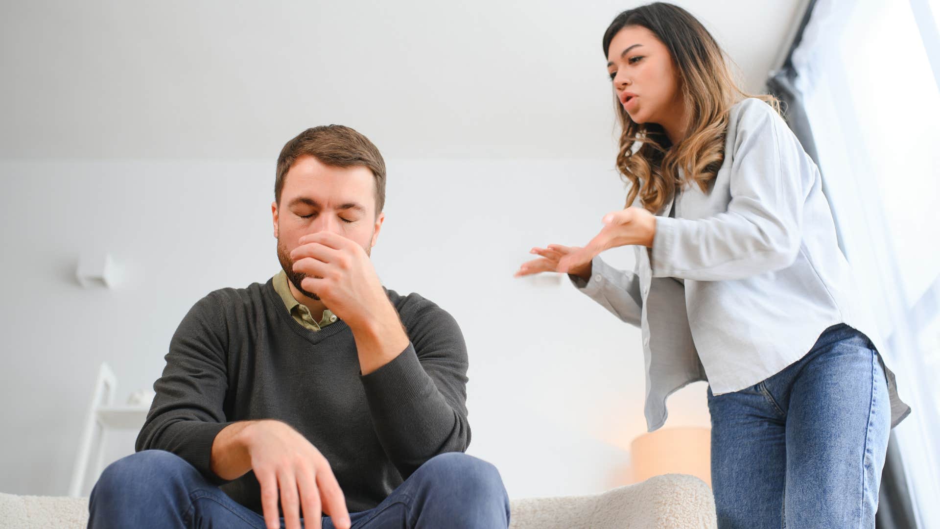 Man looking annoyed while a woman yells at him.