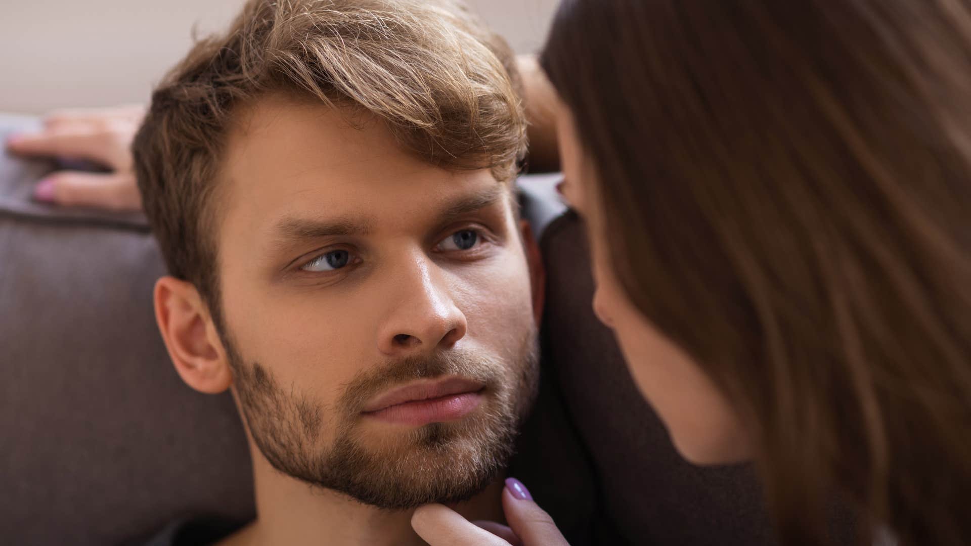 Man looking annoyed while staring at his girlfriend up close.