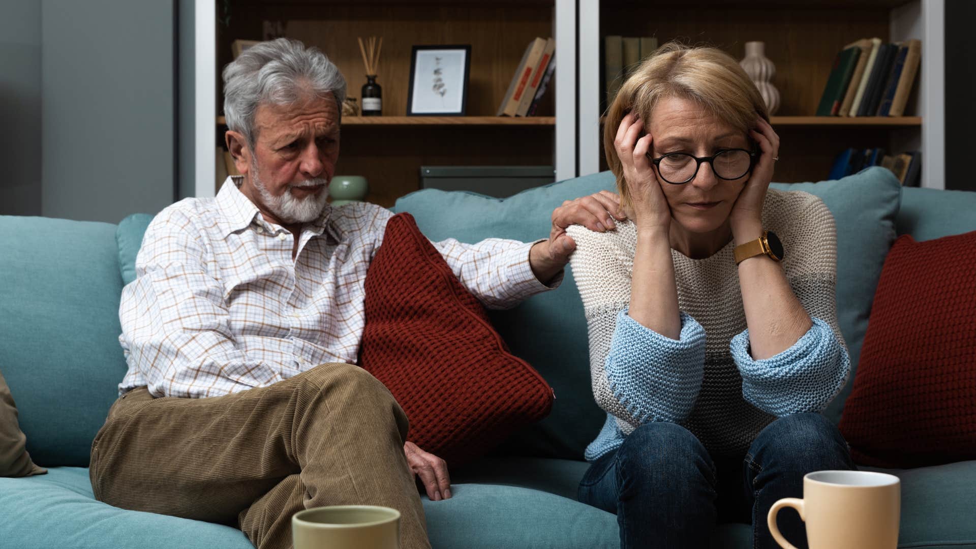 Man comforting woman looking upset on the couch.