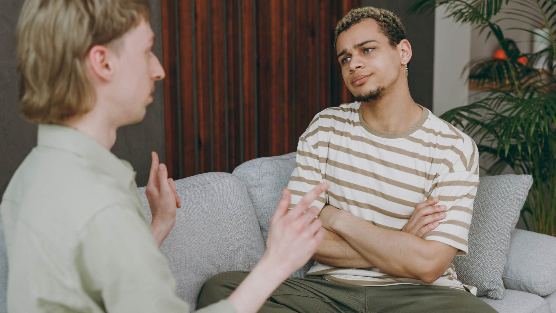 Couple arguing while sitting on the couch together.