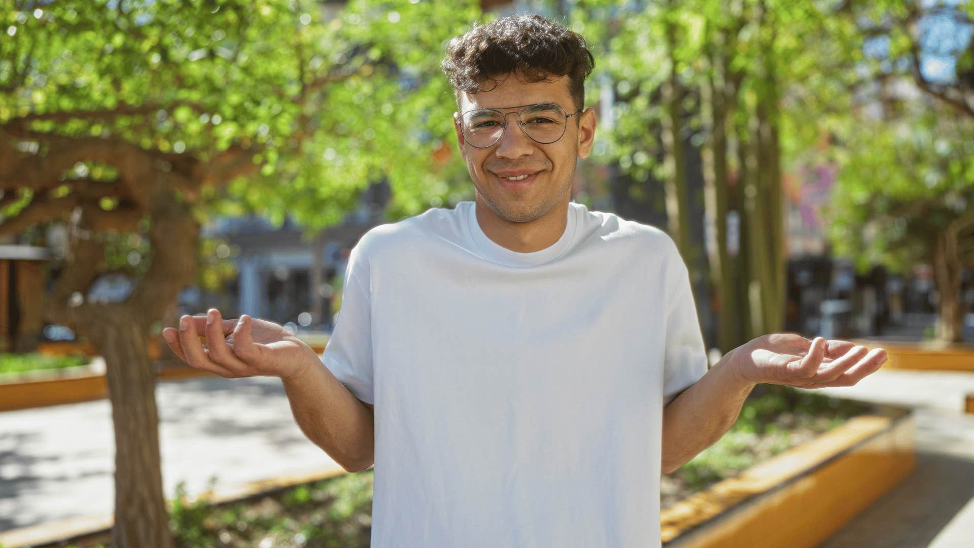 man shrugging outside in nature