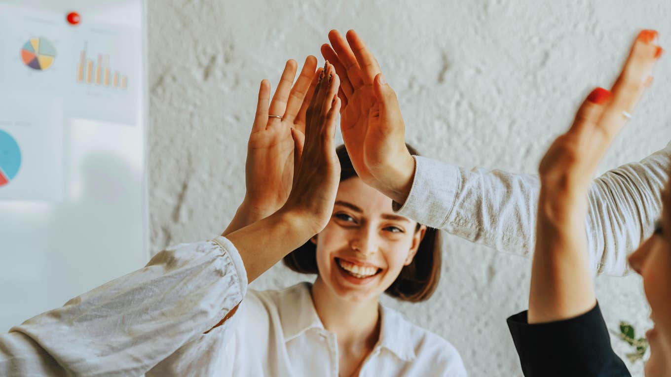 Favorite workmates giving each other high fives.