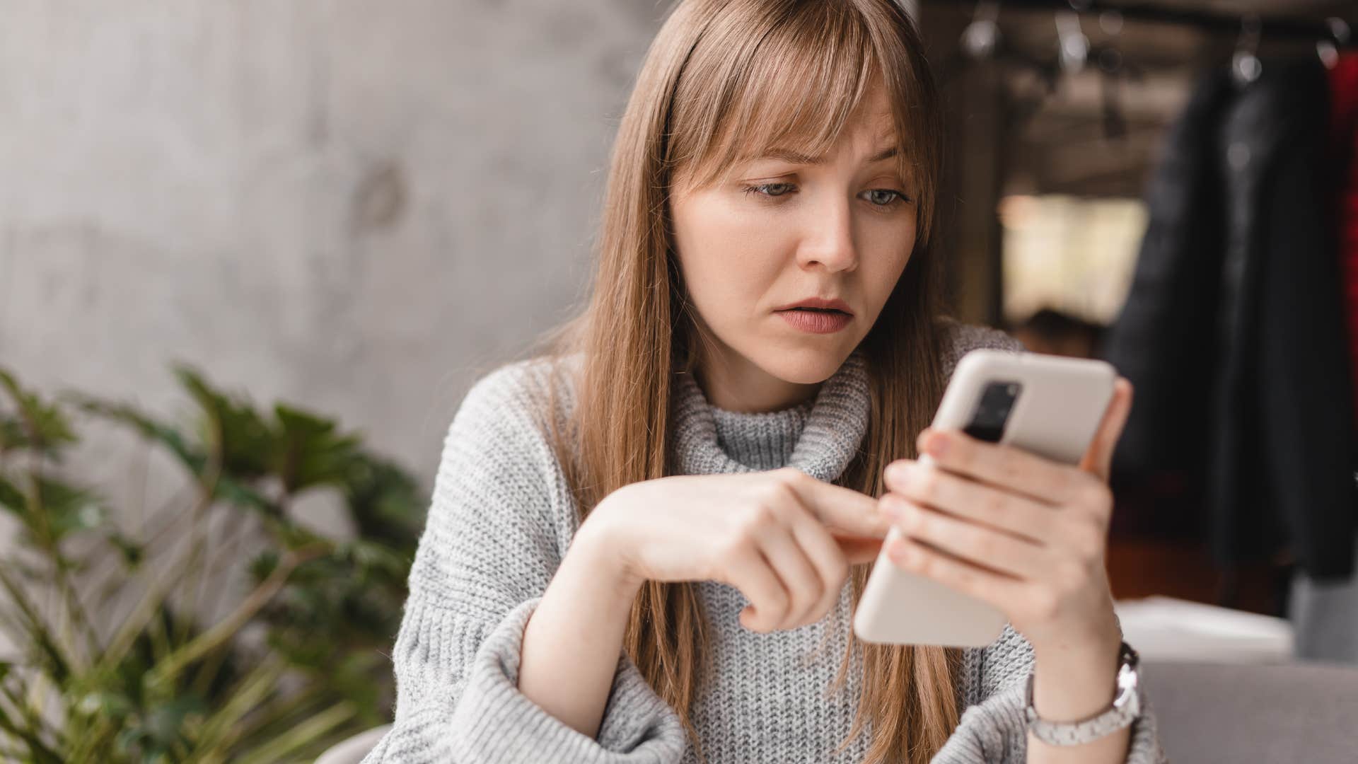 Woman looking annoyed at her cell phone.