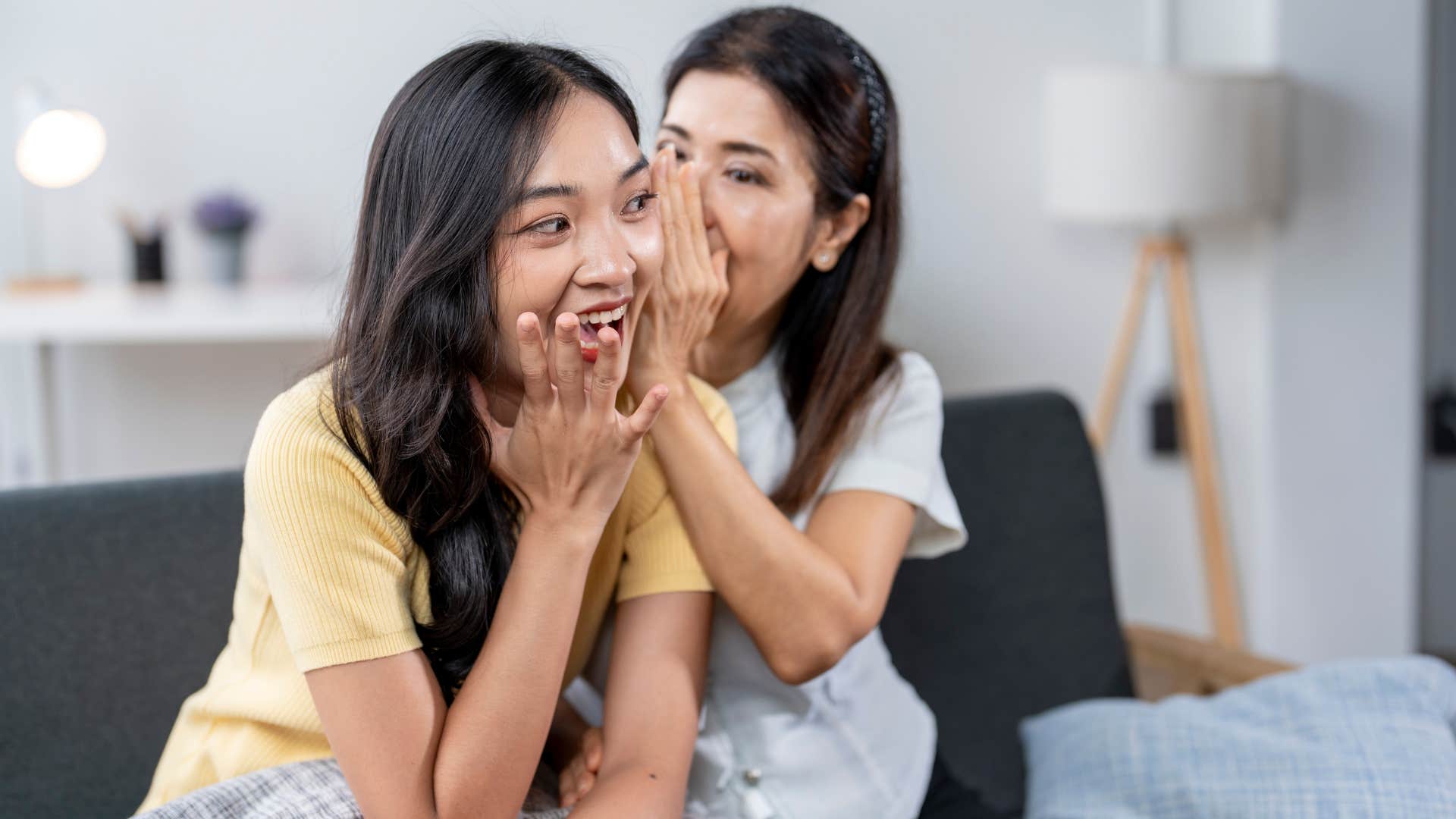 Woman telling her friend a secret.