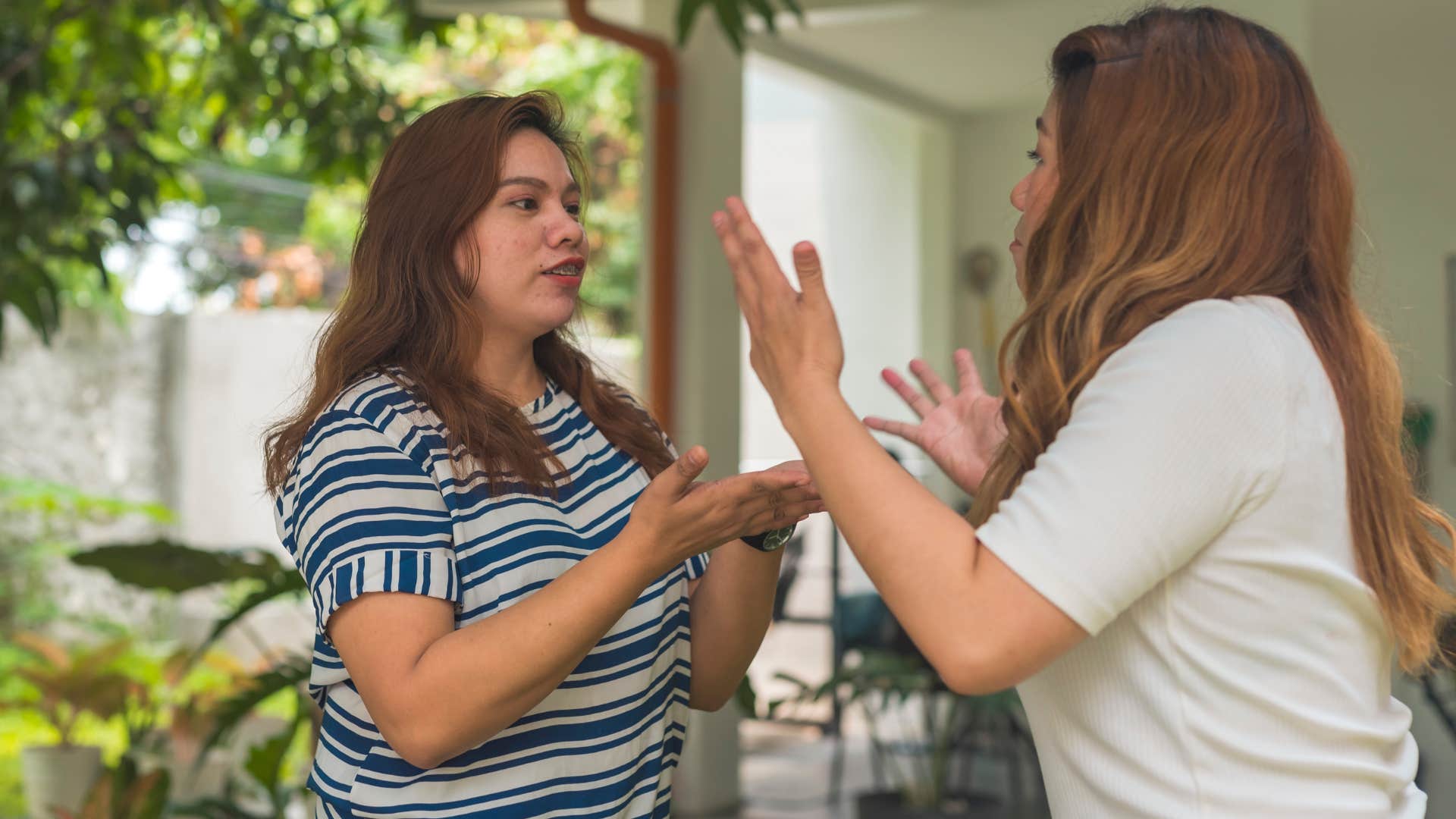 Two women arguing with each other on a porch.