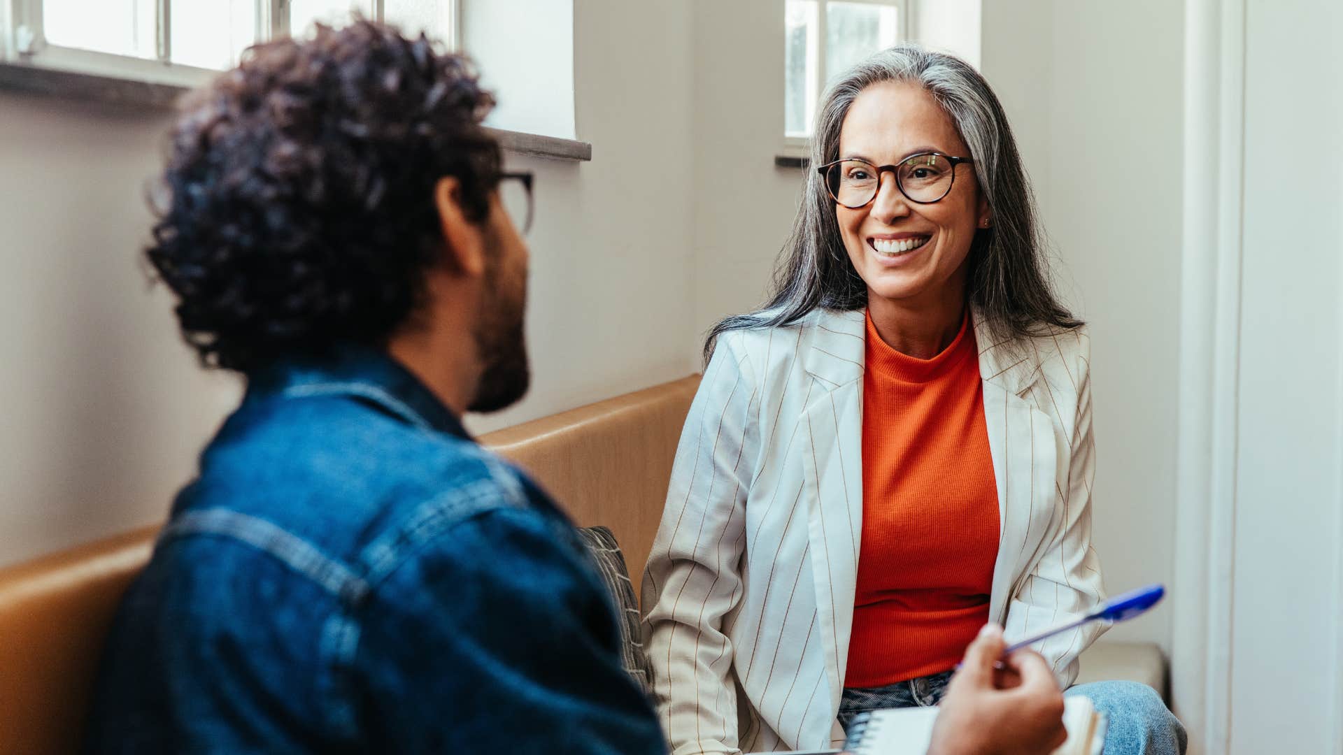 Woman smiling and talking to a man.