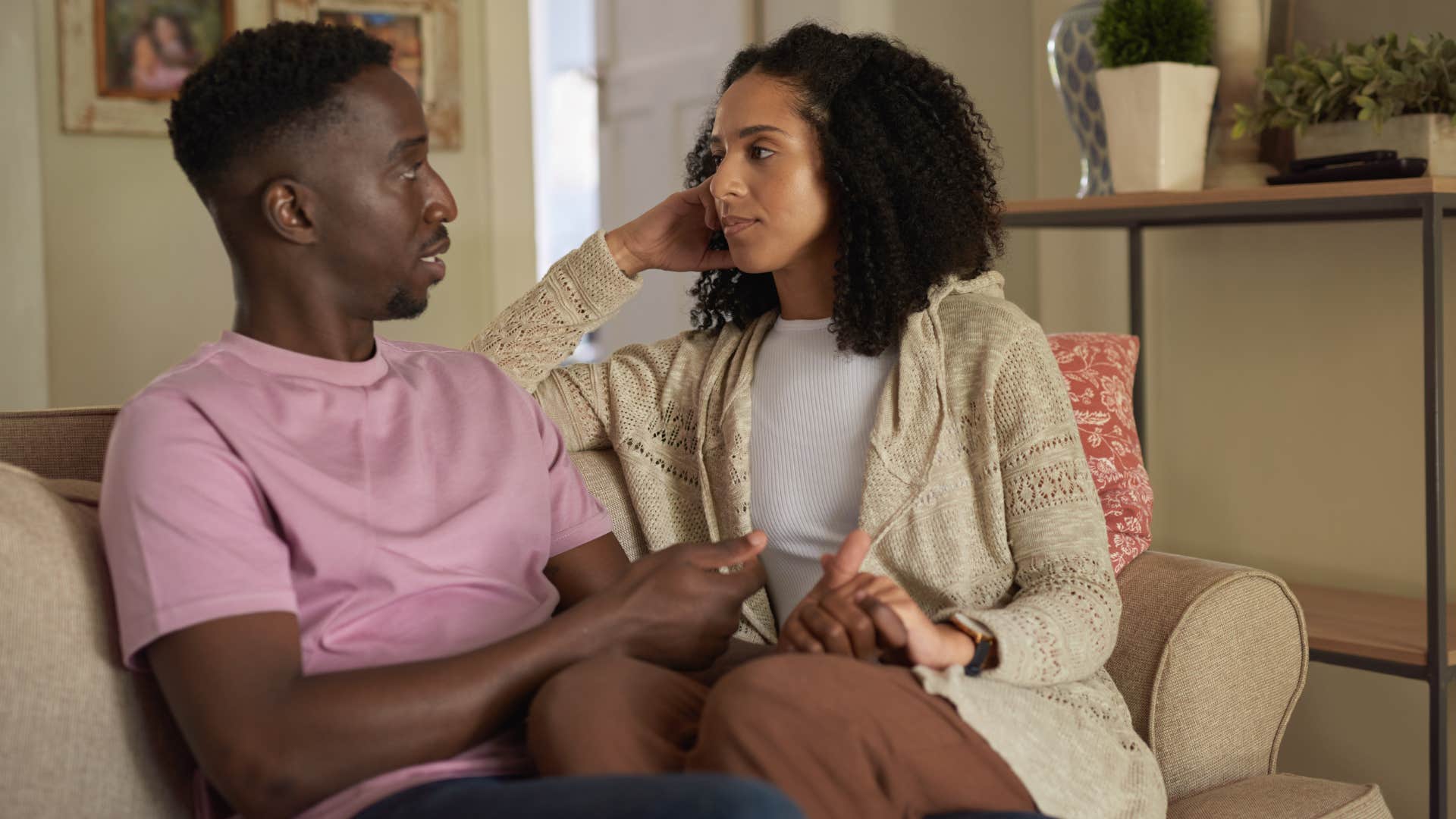 Couple having a serious conversation on a couch.