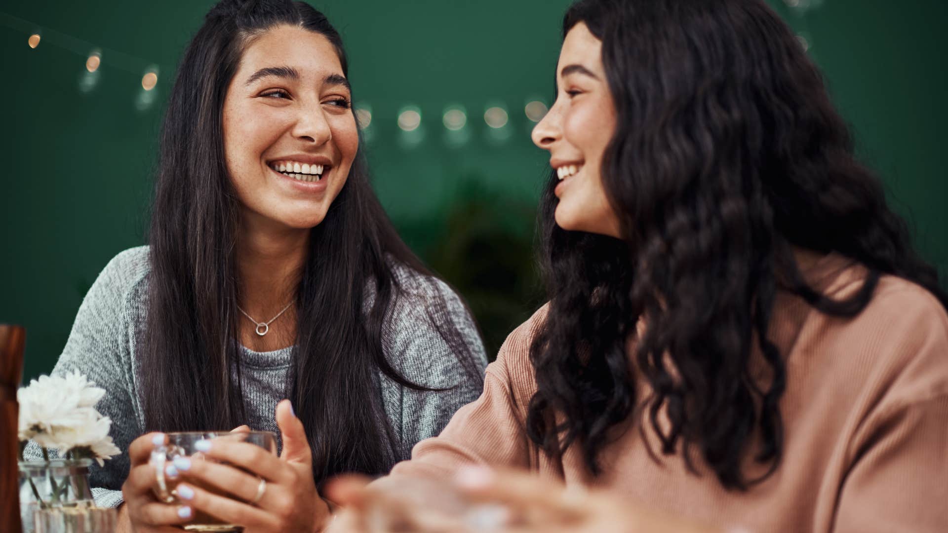 Two women smiling and talking to each other.