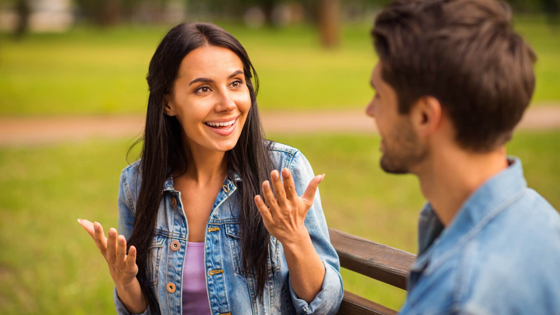 Woman smiling and talking to a man.