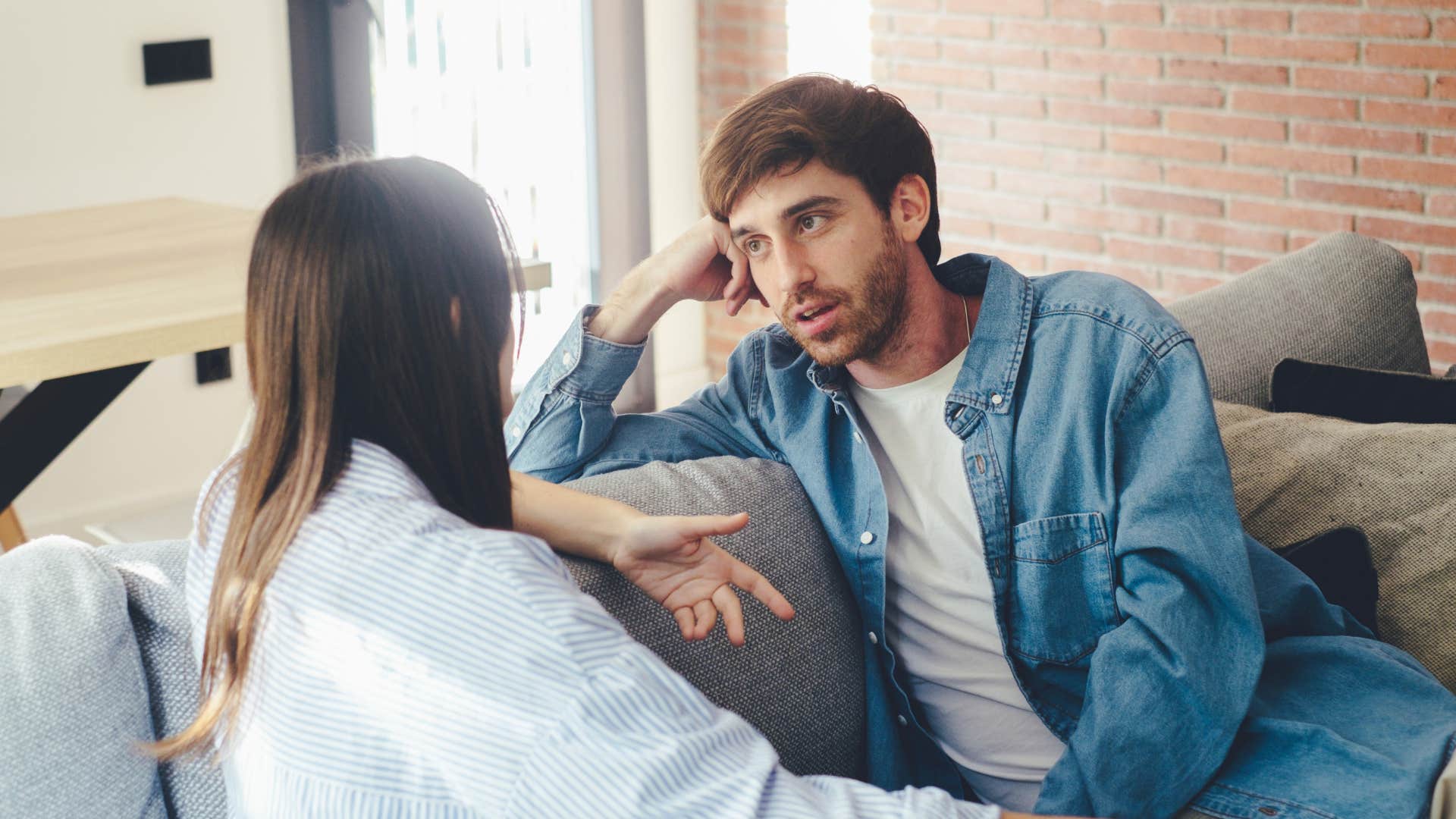 Man looking frustrated while talking to his girlfriend.