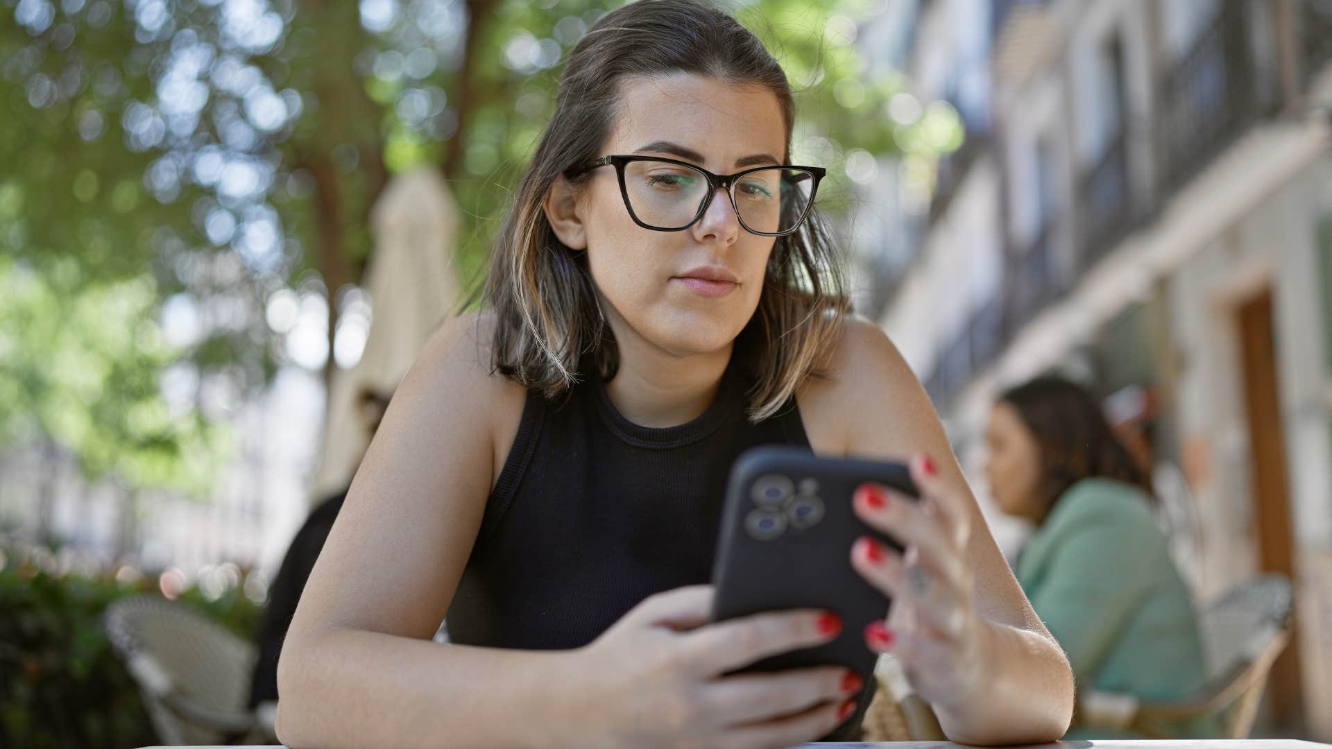 Angry woman typing on her cell phone.