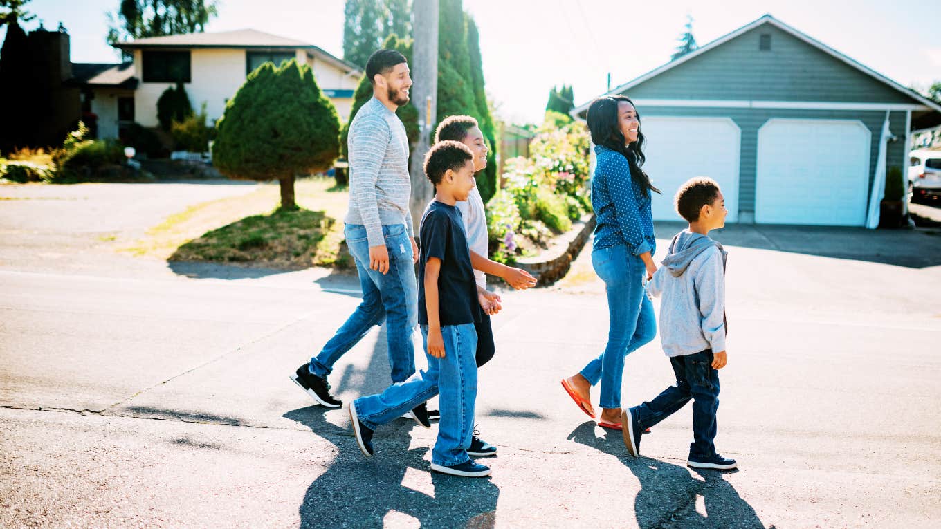 Family walking in front of homes in suburbs.