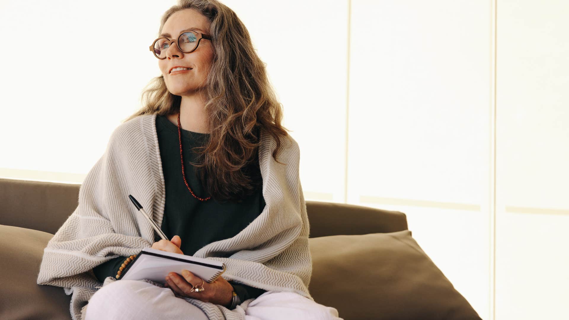 Older woman smiling and writing in a notebook