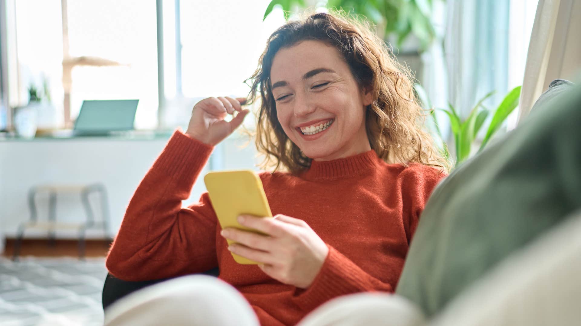 Young woman smiling while on her phone