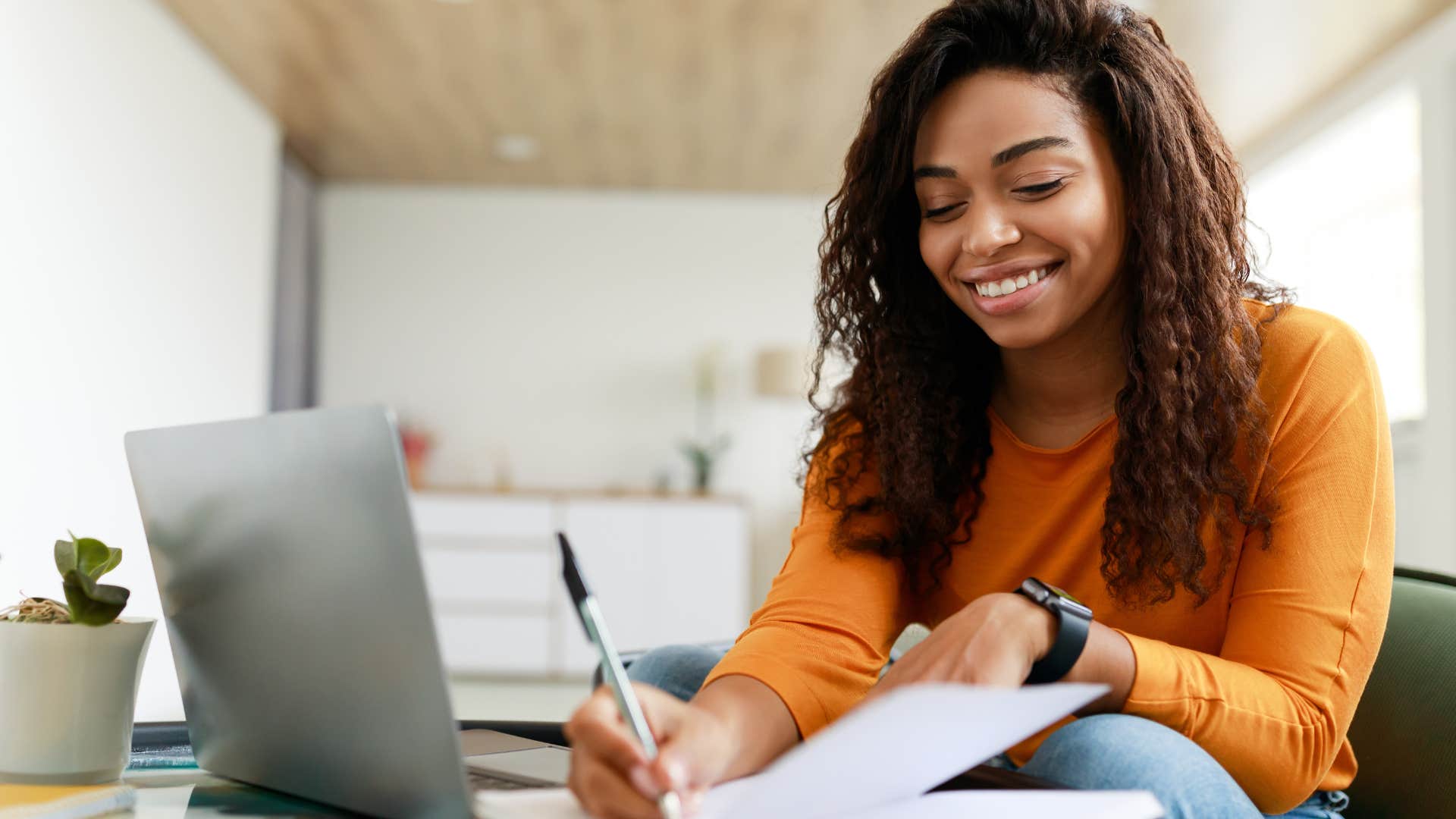 Woman smiling while writing in her notebook