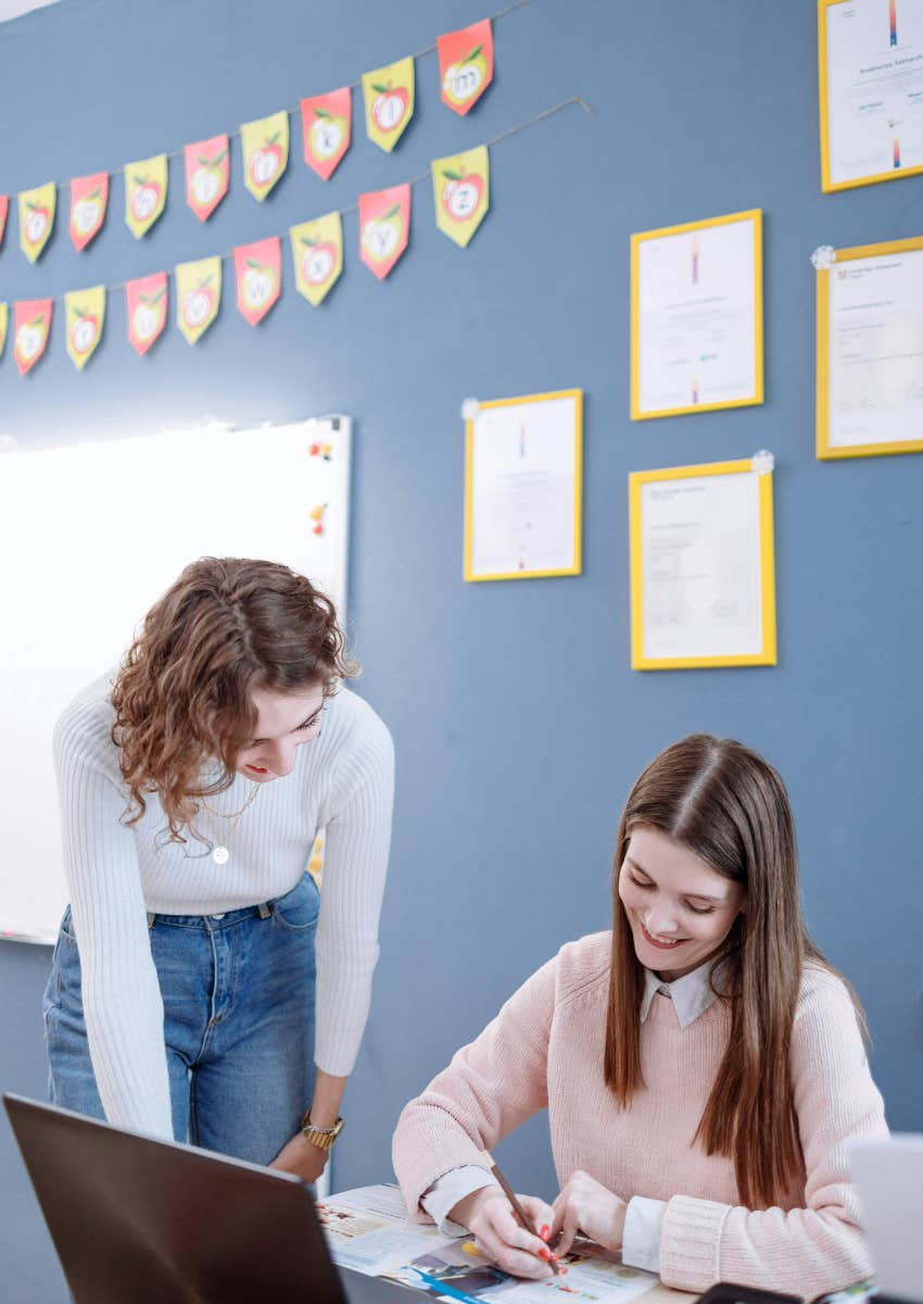 student talking to teacher at her desk