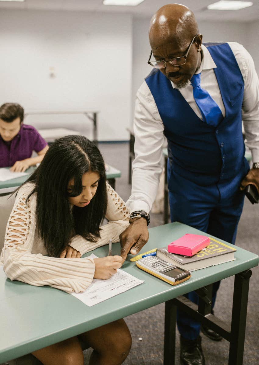 teacher assisting a student