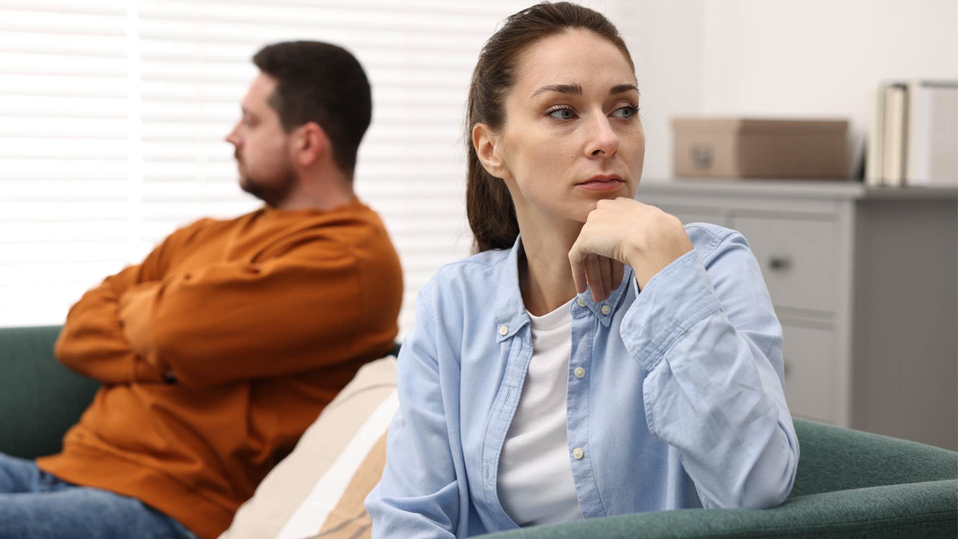 Upset woman sitting next to a man.